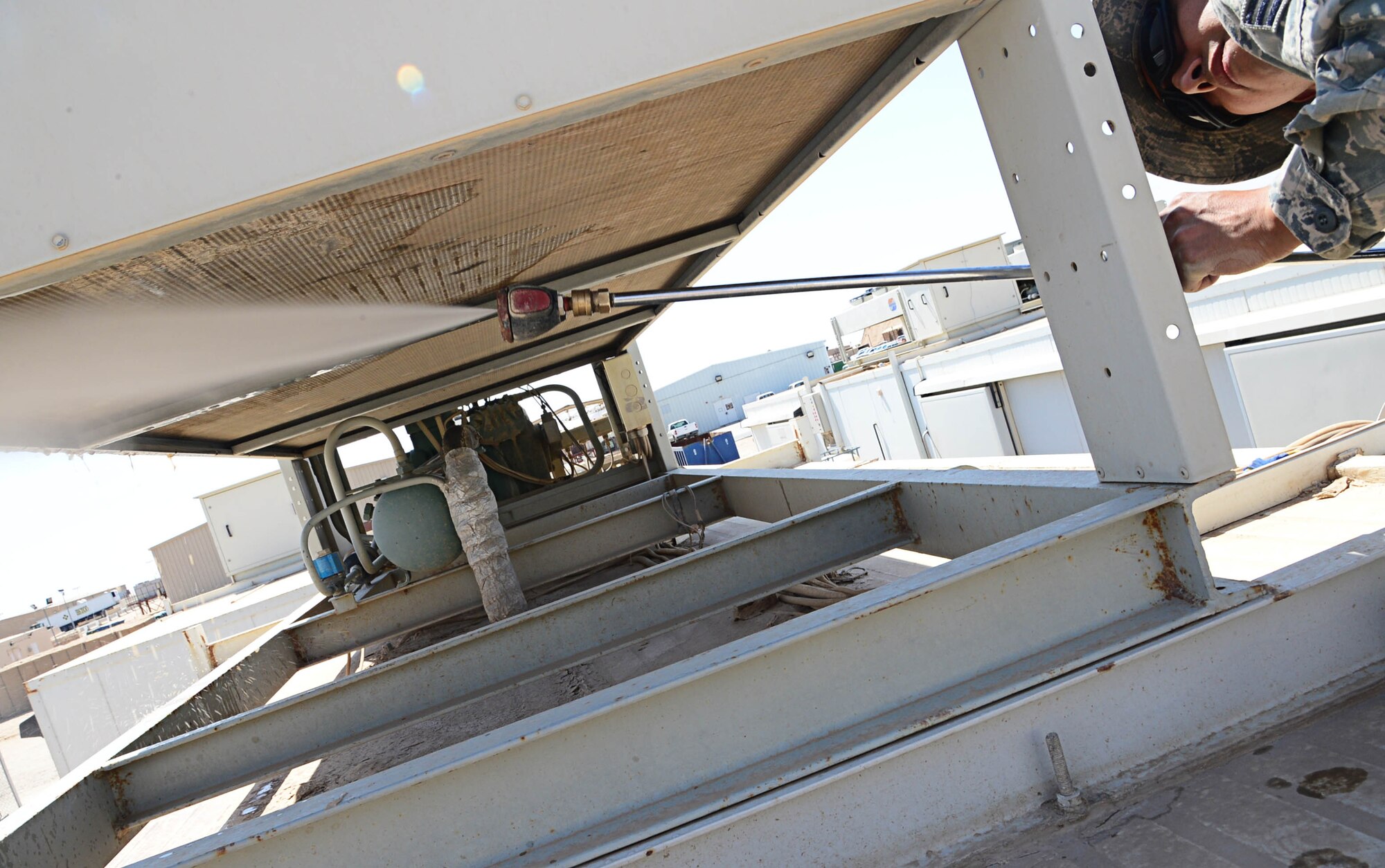 Senior Airman Mario Lopez-Casas, 386th Expeditionary Civil Engineering Squadron heat ventilation and air condition journeyman, cleans a refrigerator fan for better unit cooling at an undisclosed location in Southwest Asia. Lopez-Casas is deployed with the 146th CES, Channel Islands Air National Guard Station, Cali. (U.S. Air Force photo by Senior Airman Desiree W. Moye)