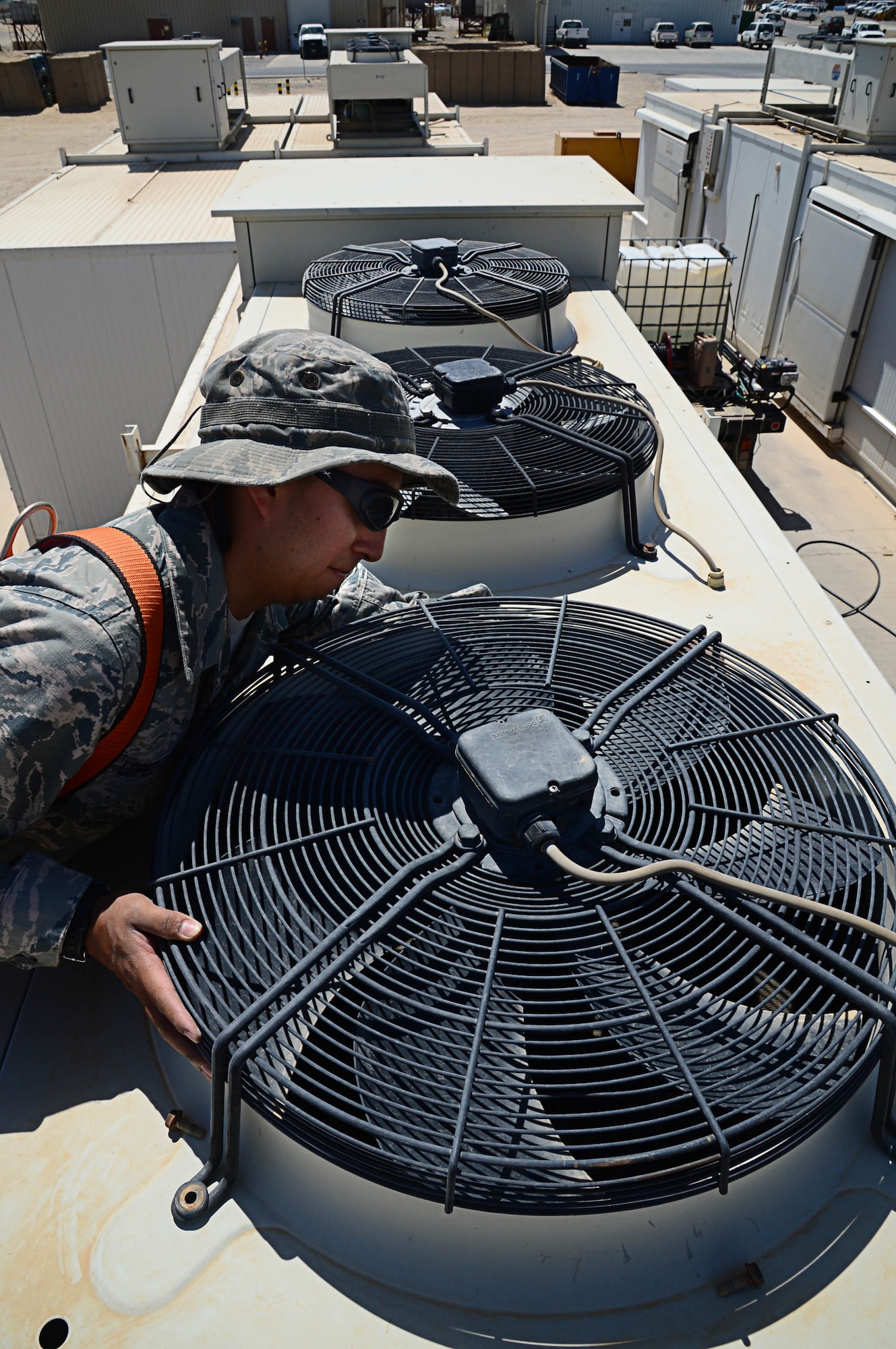 Senior Airman Mario Lopez-Casas, 386th Expeditionary Civil Engineering Squadron heat ventilation and air condition journeyman, cleans a refrigerator fan for better unit cooling at an undisclosed location in Southwest Asia. Lopez-Casas is deployed with the 146th CES, Channel Islands Air National Guard Station, Cali. (U.S. Air Force photo by Senior Airman Desiree W. Moye)