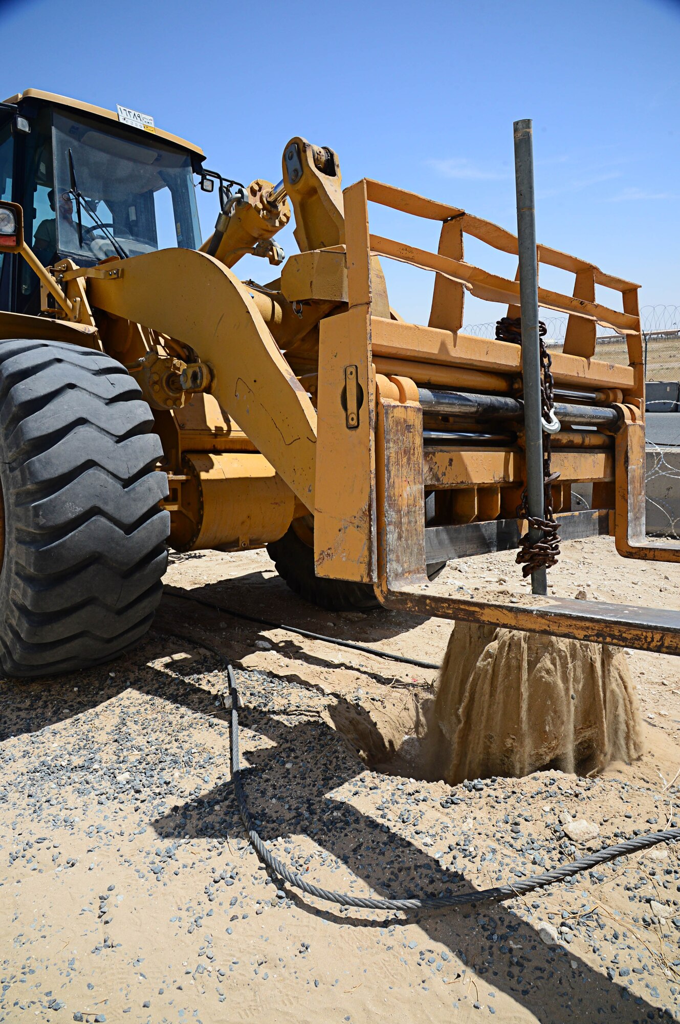 Staff Sgt. William Silva, 577th Expeditionary PRIME BEEF Squadron forklift operator, removes a fence post from the ground in preparation for a more secured perimeter barrier at an undisclosed location in Southwest Asia. Silva is deployed from Seymour Johnson Air Force Base, N.C. (U.S. Air Force photo by Senior Airman Desiree W. Moye)
