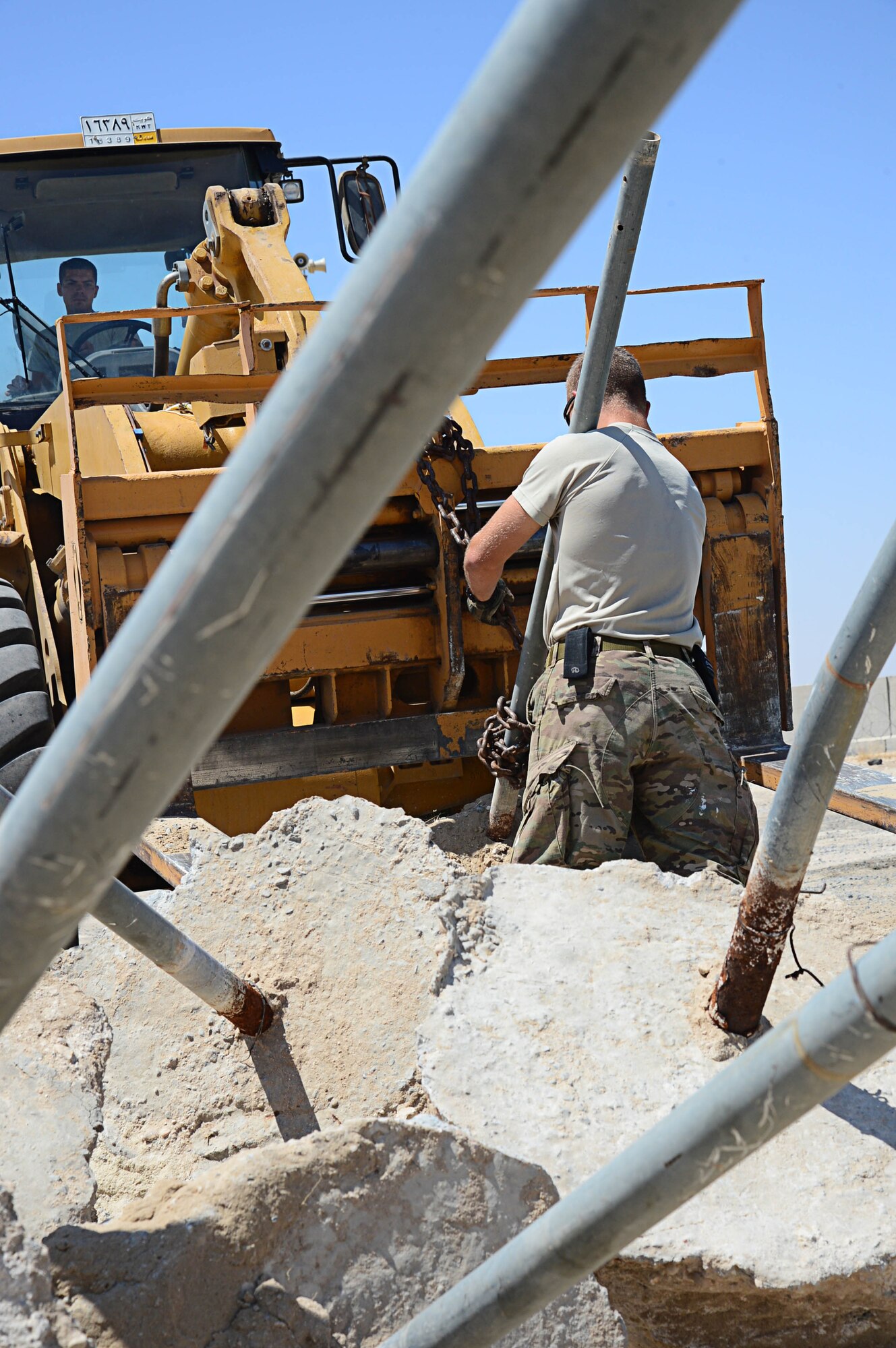 Senior Airman Nicholas Lavaring, 577th Expeditionary PRIME BEEF Squadron operations manager, removes a fence post from forklift to prepare for a more secured perimeter barrier near the visitors control center at an undisclosed location in Southwest Asia. Lavaring is deployed from Whitman Air force Base, Mo. and a native of Sydney, Australia. (U.S. Air Force photo by Senior Airman Desiree W. Moye)