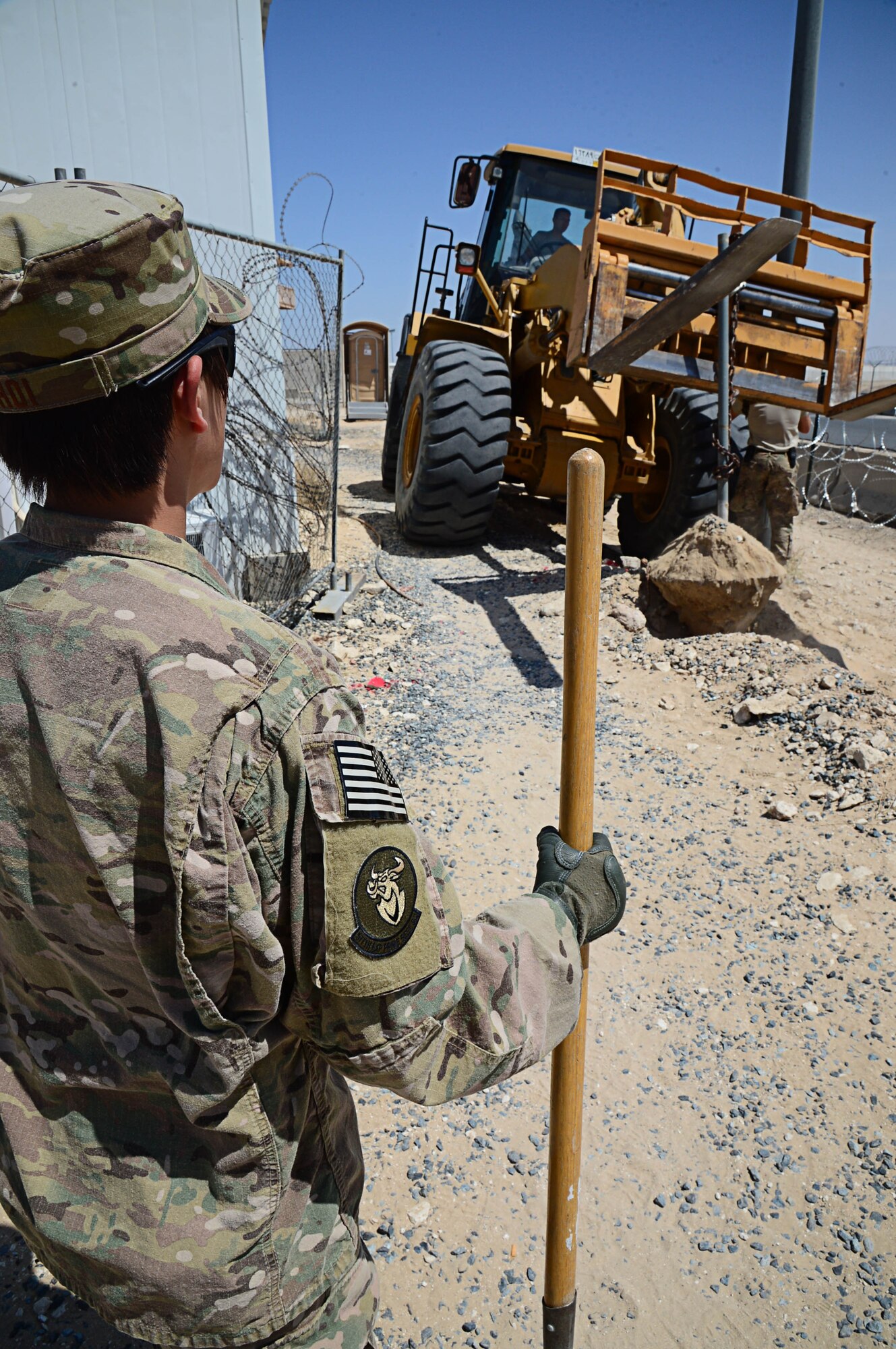Staff Sgt. Nora Choy, 577th Expeditionary PRIME BEEF Squadron engineering apprentice, oversees a visitor control center fence removal in preparation for a more secured perimeter barrier at an undisclosed location in Southwest Asia. Choy is deployed from Elmendorf Air force Base, Alaska and a native of Fairfax, Va. (U.S. Air Force photo by Senior Airman Desiree W. Moye)