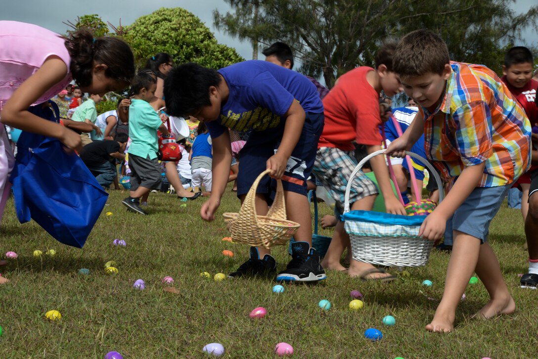 Team Andersen children collect eggs during an Easter egg hunt April 19, 2014. The Base Exchange and Andersen Network 5/6 sponsored the event which consisted of an egg hunt, games, face painting and a bounce house. (U.S. Air Force photo by Airman 1st Class Amanda Morris/Released)