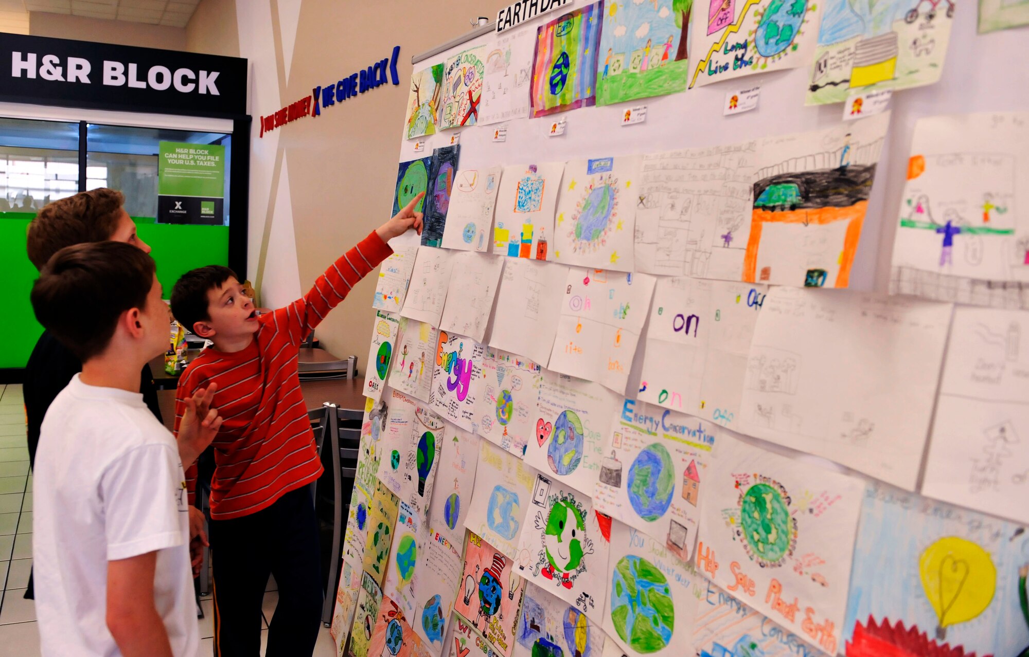 Students from Osan Elementary and Middle Schools look at posters drawn for Earth Day during the closing ceremonies at the Base Exchange on Osan Air Base Exchange, Republic of Korea, April 22, 2014. Students drew posters to demonstrate their interest in energy conservation. (U.S. Air Force photo by Senior Airman David Owsianka)