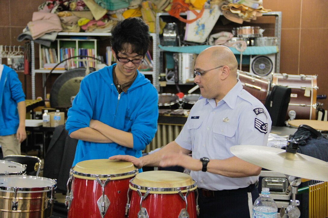 IBARAKI, Japan—Staff Sgt. Freddie Cruz, Band of the Pacific-Asia percussionist, shares conga drum technique with a music student at Tsukuba University, Tsuchiura City, Ibaraki, Japan, April 18, 2014. The event included a cultural exchange and joint performance with the University’s own “Tsukuba Jazz Orchestra” on the final day of a five-day outreach tour of the Northeast Kanto region. (U.S. Air Force photo by Staff Sgt. Geoffrey Fisher)