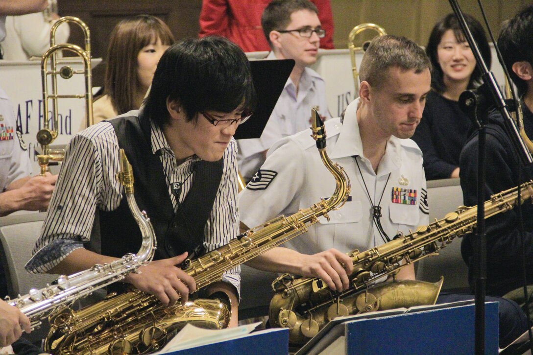 TOCHIGI, Japan—Tech Sgt. Ricky Sweum, Band of the Pacific-Asia saxophonist, studies a piece of music with a member of the “New Motley Orchestra” at Utsunomiya University, Utsunomiya City, Tochigi, Japan, April 14, 2014. The mini joint concert was part of an evening performance and cultural exchange with students at the university. (U.S. Air Force photo by Staff Sgt. Geoffrey Fisher)