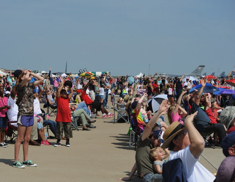 Spectators watch as the U.S. Air Force Sky Diving Team descends to the ground during the Defenders of Liberty Air Show on Barksdale Air Force Base, La., April 26, 2014. The air show included performances from local performers, an F-22 Raptor demonstration, a Heritage Flight and concluded with the U.S. Air Force Thunderbirds. (U.S. Air Force photo/Senior Airman Benjamin Gonsier)  