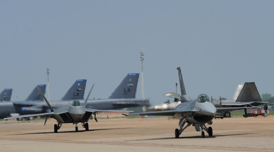 An F-16 Fighting Flacon, right, and F-22 Raptor taxi to the runway during the Defenders of Liberty Air Show on Barksdale Air Force Base, La., April 26, 2014. The F-16 and F-22 along with a P-51 Mustang, flew alongside each other during a Heritage Flight. The heritage flight performance involves an Air Force fighter piloted by an Air Combat Command trained military heritage flight pilot who flies with a historical warbird piloted by a trained and certified civilian HF pilot. (U.S. Air Force photo/Senior Airman Benjamin Gonsier)