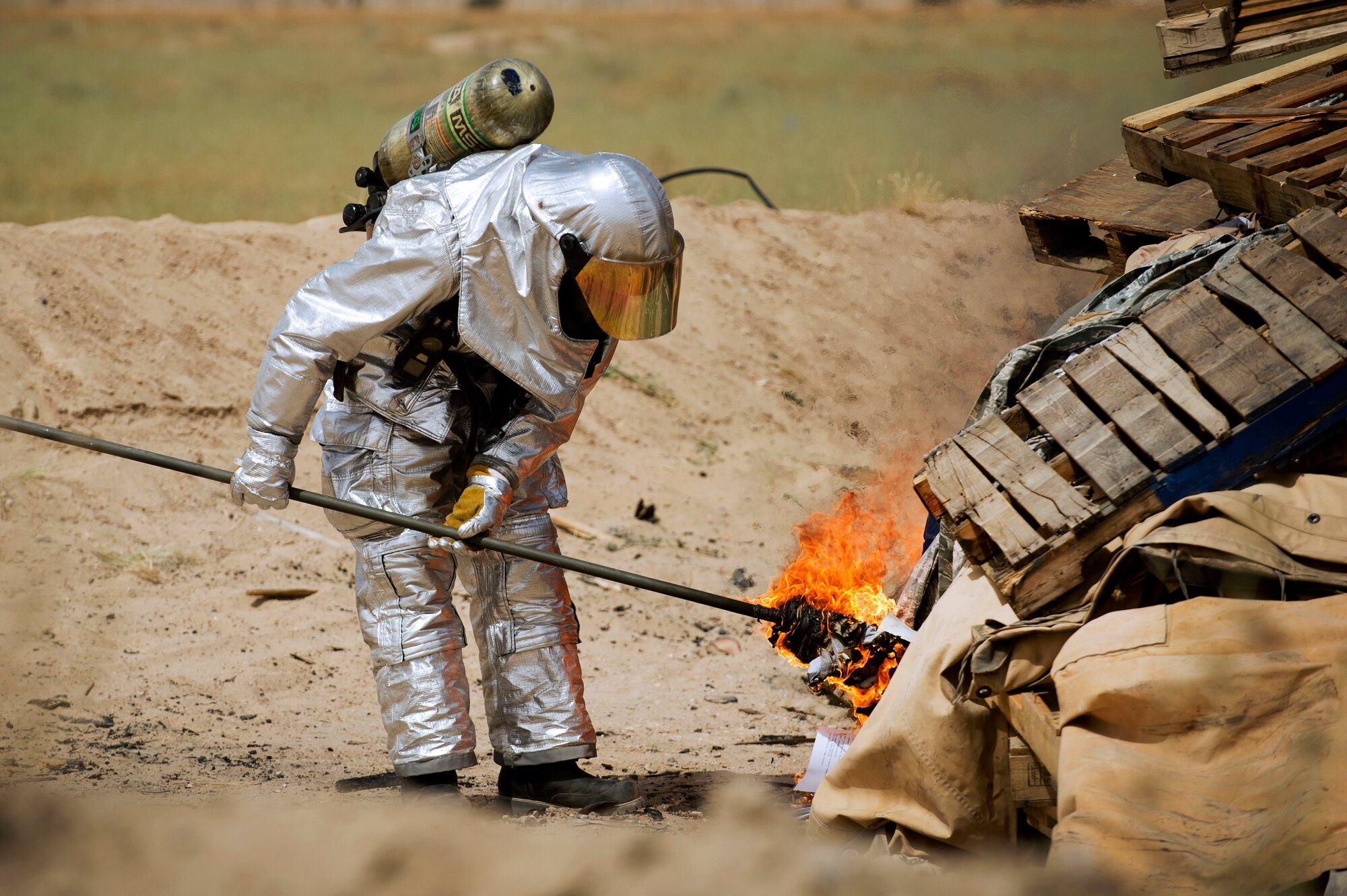 Master Sgt. Kenneth Kline, a firefigher with the 386th Expeditionary Civil Engineer Squadron, sets fire to a pile of unservicable uniform items during a training burn.  Kline is deployed from the 633rd CES, Joint Base Langley-Eustis, Va.  The burn served two purposed, the first was to destroy the excess uniform items to ensure they do not end up being utilized improperly if discarded with normal trash.  The second was to provide training for the firefighters.  (U.S. Air Force photo by Senior Master Sgt. Burke Baker)