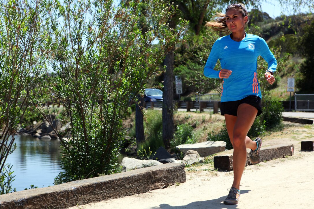Navy Lt. Traci Vander Molen, Emergency Trauma Nurse, 1st Marine Logistics Group Headquarters, runs along the Lake O’Neil path aboard Camp Pendleton, Calif., April 15, 2014, in preparation for the Boston Marathon, April 21, 2014. The bombing during last year’s marathon inspired Traci to participate in this year’s run. Traci said she is determined to run alongside her fellow racers to prove that acts of terrorism will not cause them to shy away from something they love.