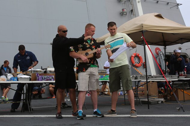 Sgt. Aren King, left, a light armored vehicle mechanic with 1st Light Armored Reconnaissance Battalion, 1st Marine Division is cheered on by his fellow Marines alongside Lance Cpl. Michael Sigur, a supply clerk with 1st Maintenance Battalion, 1st Marine Logistics Group. King and Sigur won second and third place respectively during a talent show as part of Steel Beach, a barbecue held aboard amphibious transport dock ship USS Anchorage (LPD 23) to build unit cohesion, April 13, 2014, as part of Special Purpose Marine Air Ground Task Force Association of Southeast Asian Nations. SPMAGTF-ASEAN, aboard Anchorage, recently completed a mission to support U.S. Secretary of Defense Chuck Hagel during a press conference with delegates and media personnel from the ASEAN in Hawaii, April 1-4, 2014 and is currently at sea conducting further training and maintenance on equipment. King is from Orlando, Fla.