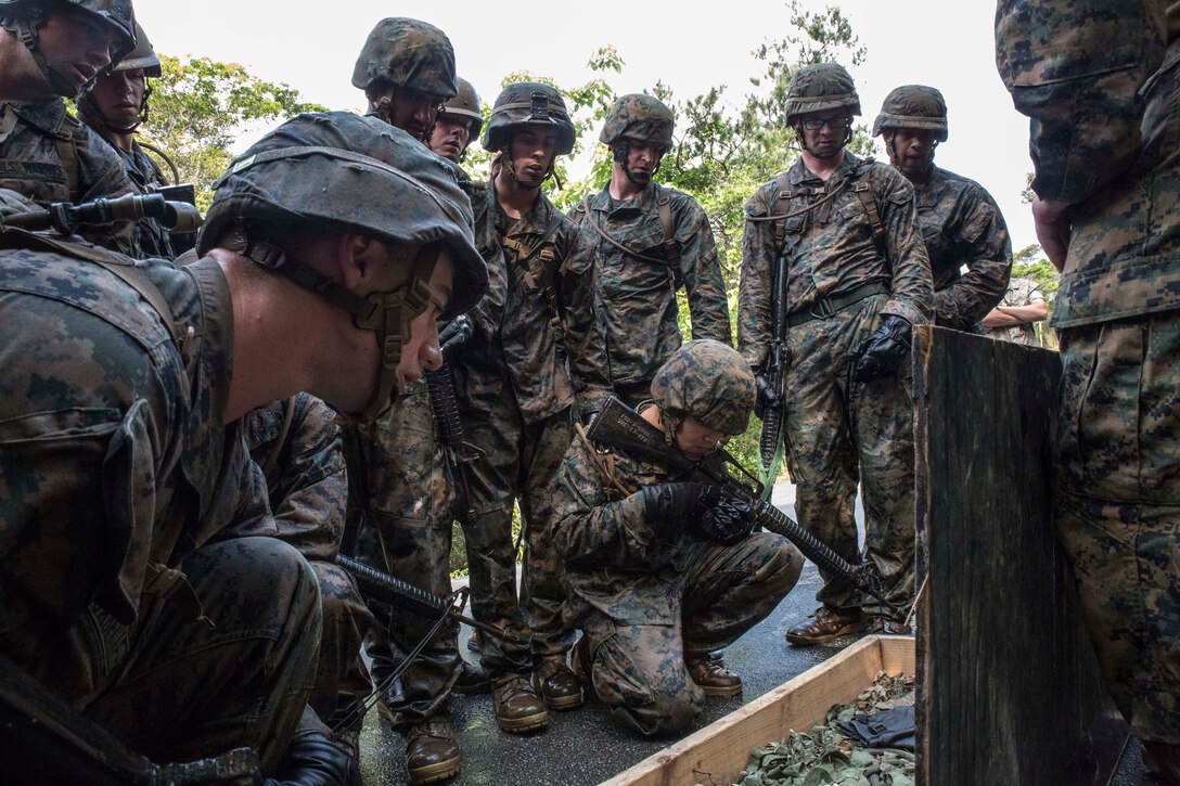 Marines memorize items contained in a box as part of a “Kim’s game” during an endurance course April 17 at the Jungle Warfare Training Center on Camp Gonsalves. The Marines look at the items early in the course and then have to tell the instructors what items were in the box just before the last leg of the event. The simple game tests the participant’s mental capacity while enduring stressful and fatiguing activity. The Marines are with various units assigned to Combat Assault Battalion, 3rd Marine Division, III Marine Expeditionary Force. (U.S. Marine Corps photo by Cpl. Stephen D. Himes/Released)