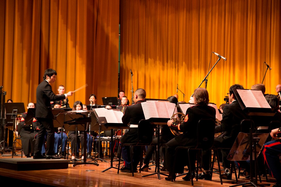 Takeshi Takasaki, far left, conducts a performance by students of the University of the Ryukyus Wind Orchestra Band Club and Marines with the III Marine Expeditionary Force Band March 14 during a combined concert at the Camp Foster Theater. “I am very happy that university students and Marine band members joined forces,” said Takasaki. “It was a great success.” Takasaki is the conductor of the University of the Ryukyus Wind Orchestra Band Club. 