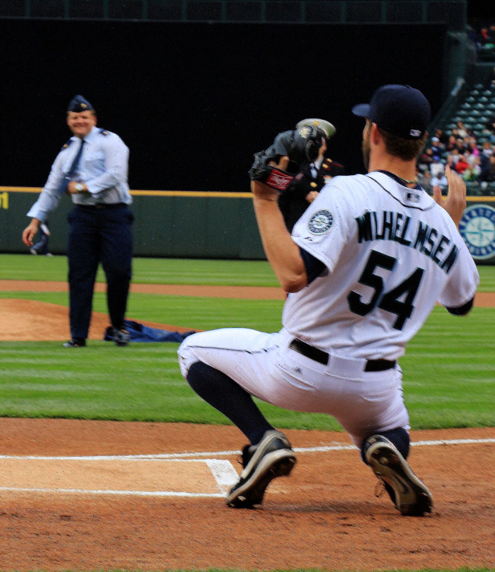 Maj. Marc Miller, 97th Airlift Squadron standardization and evalutaion officer, throws the first pitch to Seattle Mariners player Tom Wilhelmsen at Safeco Field in Seattle during a pre-game ceremony for the 2014 Seattle Mariners Salute to Armed Forces Night on April 26. Miller, who is originally from Eatonville, Wash., played baseball at the college level and was excited for the opportunity to represent the Air Force Reserve before the game. (U.S. Air Force Reserve Photo by Senior Airman Madelyn McCullough)