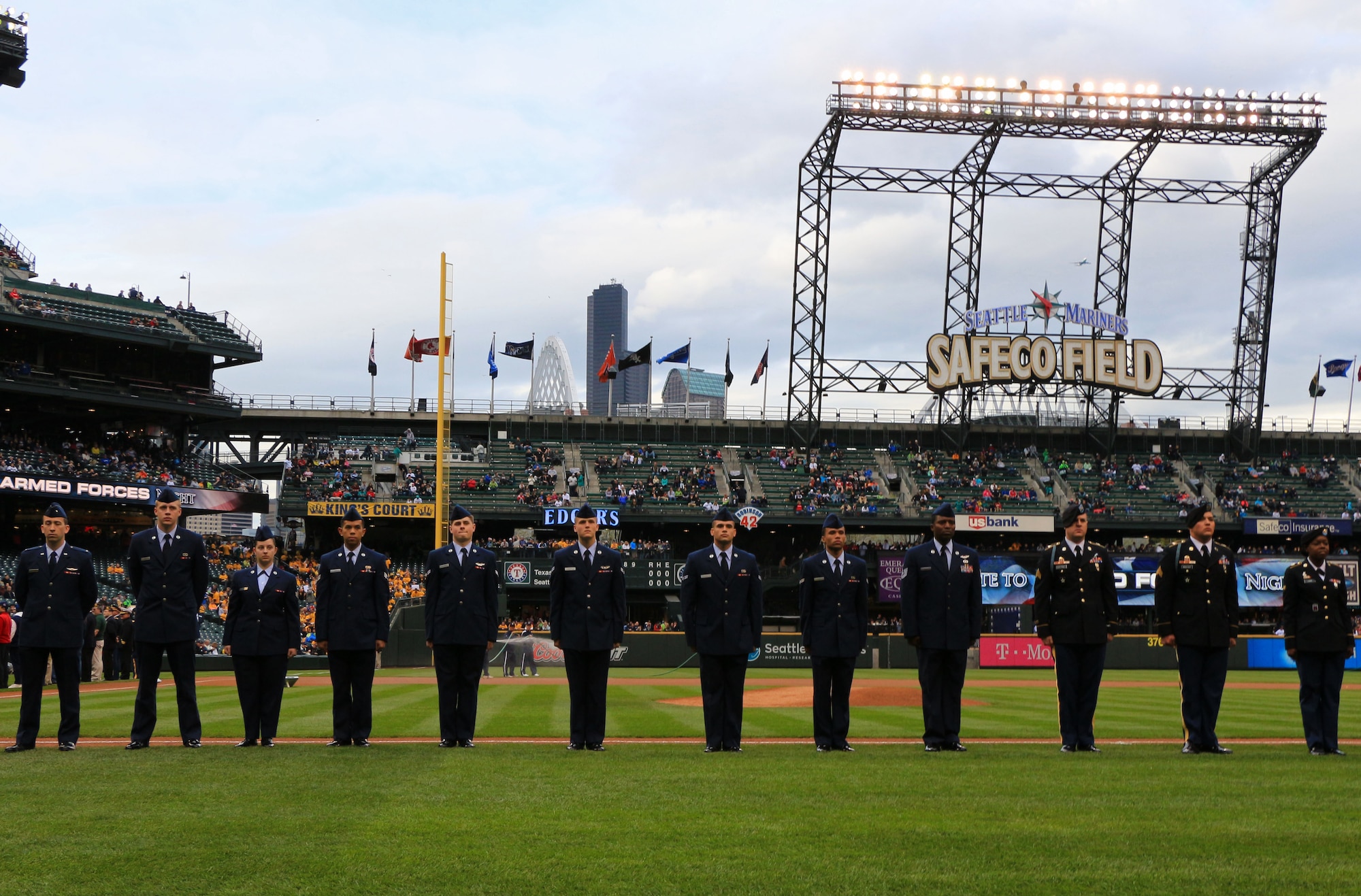 Service members stand on the Safeco Field baseline in Seattle during a pre-game ceremony for the 2014 Seattle Mariners Salute to Armed Forces Night on April 26. These service members, including three 446th Airlift Wing Reservists, stood with members of the Mariners baseball team during the playing of the National Anthem. The Reservists from the 446th AW included Senior Airman Bonn Abad and Airman Austin Jodzko of the 446th Aircraft Maintenance Squadron and Senior Airman Sheriah Coburn of the 446th Maintenance Group. (U.S. Air Force Reserve Photo by Senior Airman Madelyn McCullough)