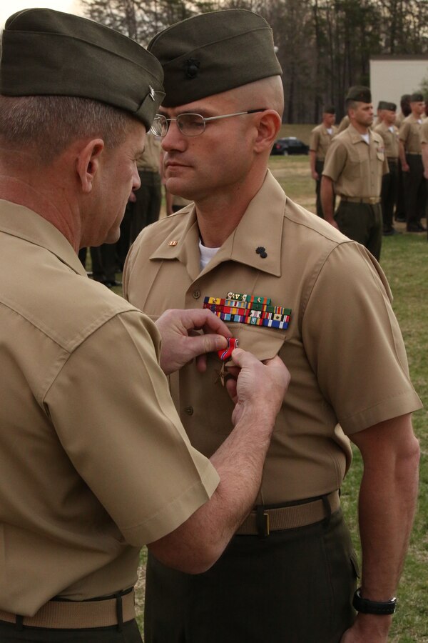 Col. Colonel Todd S Desgrosseilliers, commanding officer of The Basic School, pins the Bronze Star Medal with combat distinguishing device onto Warrant Officer Jeremy Barone at The Basic School aboard Marine Corps Base Quantico on April 11, 2014. Barone received the award for heroic service while serving as the first sergeant with Co. F, 2nd Bn., 8th Marines, 2nd Marine Expeditionary Force Headquarters Group Forward, from April- October 2013, while deployed to Afghanistan during Operation Enduring Freedom.