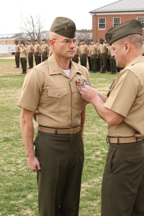 Col. Colonel Todd S Desgrosseilliers, commanding officer of The Basic School, pins the Bronze Star Medal with combat distinguishing device onto Warrant Officer Jeremy Barone at The Basic School aboard Marine Corps Base Quantico on April 11, 2014. Barone received the award for heroic service while serving as the first sergeant with Co. F, 2nd Bn., 8th Marines, 2nd Marine Expeditionary Force Headquarters Group Forward, from April- October 2013, while deployed to Afghanistan during Operation Enduring Freedom.