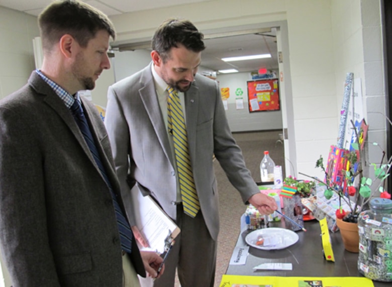 Wesley Malone and Robert Mackey, Huntsville Center project managers, look over students Earth Day projects at the First Missionary Baptist Church Child Development Center and Academy April 22.