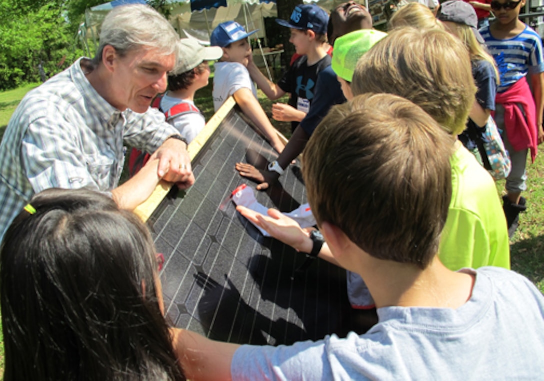 Jeff Waters, an instructor at Calhoun Community College's Clean Energy Center, explains solar technology using a solar panel during Earth Day April 24 at the Path to Nature. The students are from Horizon Elementary School.                      