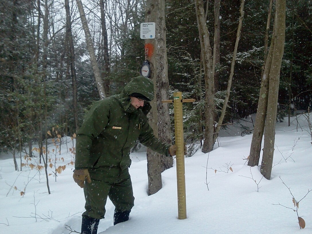 A park ranger performs a snow survey at Birch Hill Dam, Royalston, Mass.