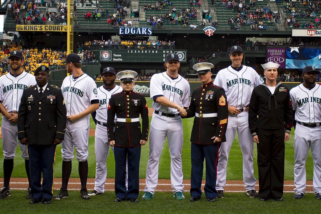 U.S. Marine Gunnery Sgt. Buck Flowers (fourth from right), a recruiting staff noncommissioned officer with Marine Corps Recruiting Station Seattle, shakes hands with Seattle Mariners pitcher Blake Beaven during a Mariners’ Salute to Armed Forces Night at Safeco Field in Seattle, April 26, 2014. The event included the presentation of commemorative plaques to senior military leaders, a joint-service color guard and flag presentation, military band performances and ceremonial first pitches thrown out by members of each service. Flowers, 33, is from Mesquite, Texas. (U.S. Marine Corps photo by Sgt. Reece Lodder)