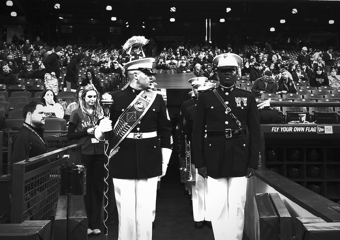 U.S. Marine Gunnery Sgt. Benjamin Becker (left), drum major, 1st Marine Division Band, yells a command for the band to march onto the field to perform the National Anthem before a Major League Baseball game between the Seattle Mariners and Texas Rangers at Safeco Field in Seattle, April 25, 2014. The 1st Marine Division Band, directed by Chief Warrant Officer 3 Edward Hayes, is comprised of 50 U.S. Marine musicians and based at Marine Corps Base Camp Pendleton, Calif. (U.S. Marine Corps photo by Sgt. Reece Lodder)