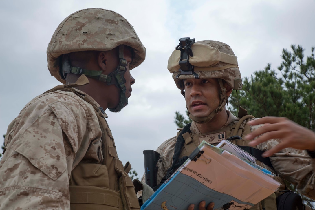 Capt. Jonathan G. White, left, speaks with Cpl. Kumasi I. Allen, during a command post exercise April 23 in the Central Training Area near Camp Hansen. Allen is a Milwaukee native and field wireman with Headquarters Battery, 12th Marine Regiment, 3rd Marine Division, III Marine Expeditionary Force. White is a Gaithersburg, Md., native and the commanding officer of the battery.