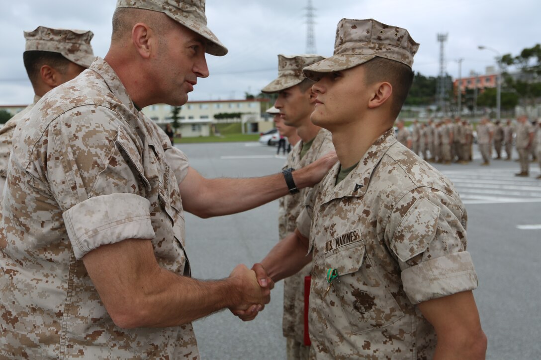 Lance Cpl. Steward M. Bach, right, is awarded the Navy and Marine Corps Achievement Medal by Col. Lance A. McDaniel April 25 at Camp Hansen. Bach and two other Marines used emergency medical techniques to save the life of a fellow Marine, who suffered a heart attack. “I think this sends a message to people, not just to those in uniform, but everyone,” said Bach. “If someone needs help, then we will be there for them. I’m just proud to be part of an organization where people I’ve never met can come to me and say, ‘good job.’” Bach is a fire support man with Headquarters Battalion, 12th Marine Regiment, 3rd Marine Division, III Marine Expeditionary Force. McDaniel is the commanding officer of the battalion. (U.S. Marine Corps photo by Lance Cpl. Matt Myers/Released)      