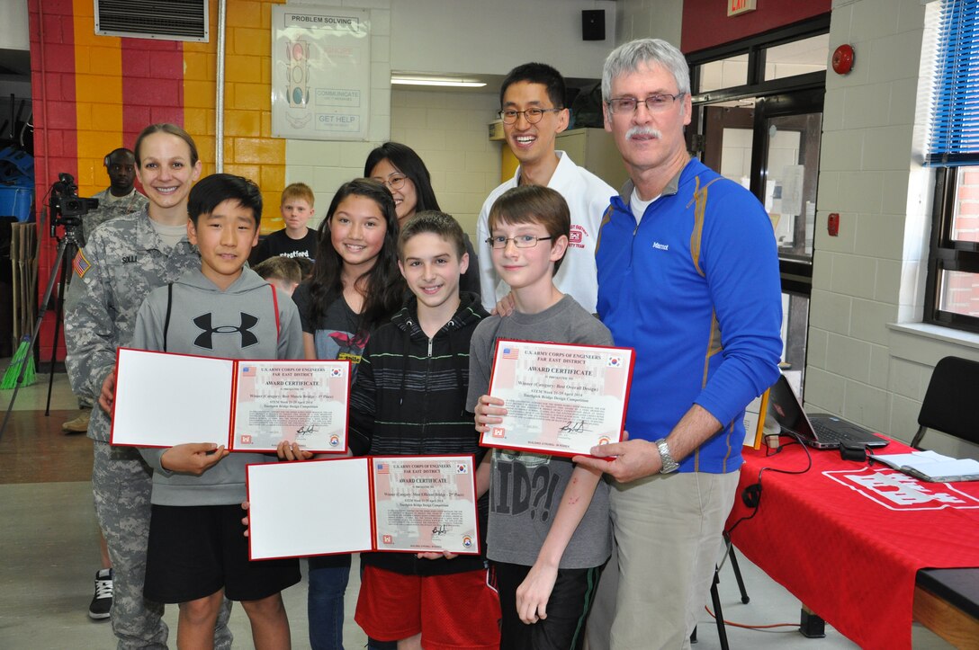Kim Min-sung (front left), Kara Ohler, Jeremy Sumpter and Austin Barberree, pose with Far East District engineers as they accept their certificates for winning this year’s toothpick bridge competition for best overall design.