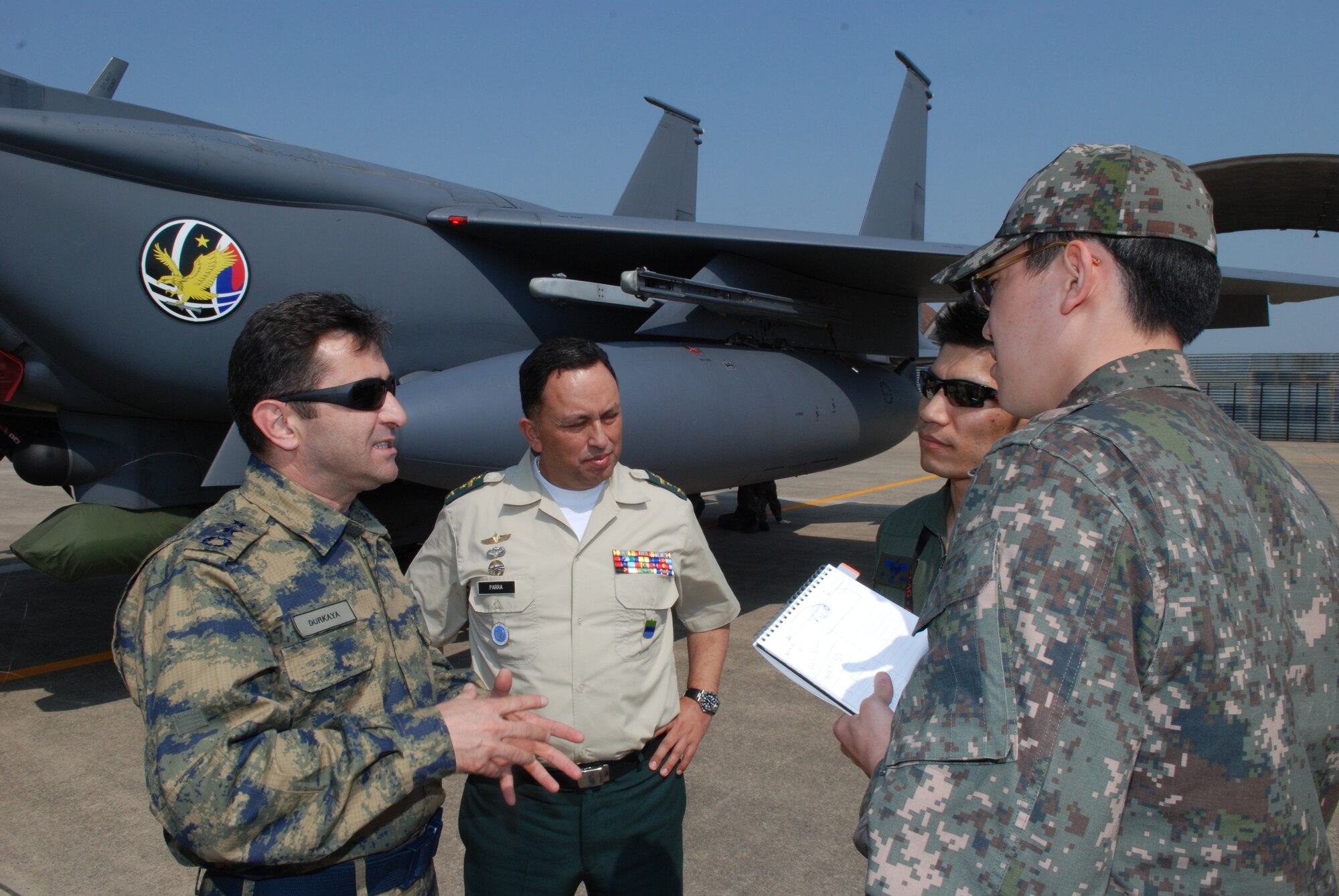 GWANGJU AIR BASE, Republic of Korea - Turkish Air Force Maj. Sinan Durkaya, Turkish Air Force attache, and Colombian Army Col. Cesar Parra, talk to members of the Republic of Korea Air Force about the capabilities of the F-15K Slam Eagle during a visit to Gwangju Air Base, April 23. Air attaches and members of the Neutral Nations Supervisory Commission visited Gwangju to observe Exercise Max Thunder, a combined, joint air combat exercise that replicates scenarios and planning cycles in a robust exercise setting that simulates combined operations against a hostile force and provides large-force employment training for U.S. and ROK military personnel. (U.S. Air Force photo by Tech. Sgt. Thomas J. Doscher)