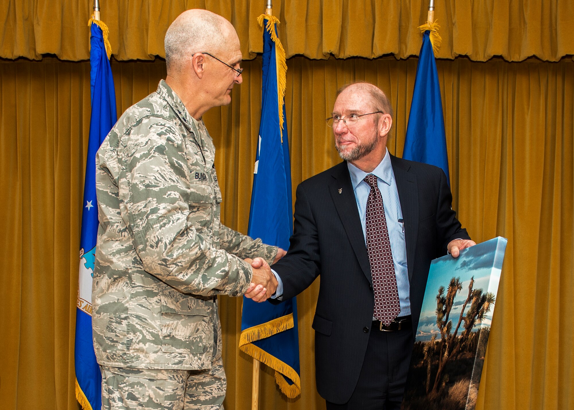 Maj. Gen. Arnold W. Bunch Jr., Air Force Test Center commander, congratulates Dr. Davy Belk, outgoing AFTC executive director, at Davy's retirement luncheon at Club Muroc April 23. (U.S. Air Force photo by Edward Cannon)