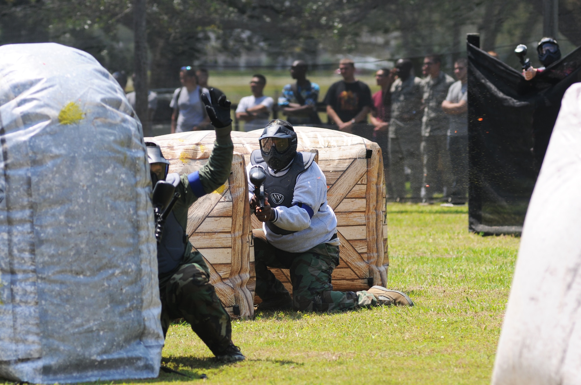 Col. George Tombe, 81st Training Group commander, waves for the attention of the referees after being hit by a paintball as his team-mate, Col. Mark Vivians, 81st Mission Support Group commander, keeps his eyes on the enemy during a friendly match between the Colonels and the Chiefs at the paintball facility grand opening April 25, 2014, southeast of the commissary at Keesler Air Force Base, Miss.  The paintball facility was funded with a portion of the 2013 Commander-in-Chief Installation Excellence award funds.  (U.S. Air Force photo by Kemberly Groue)