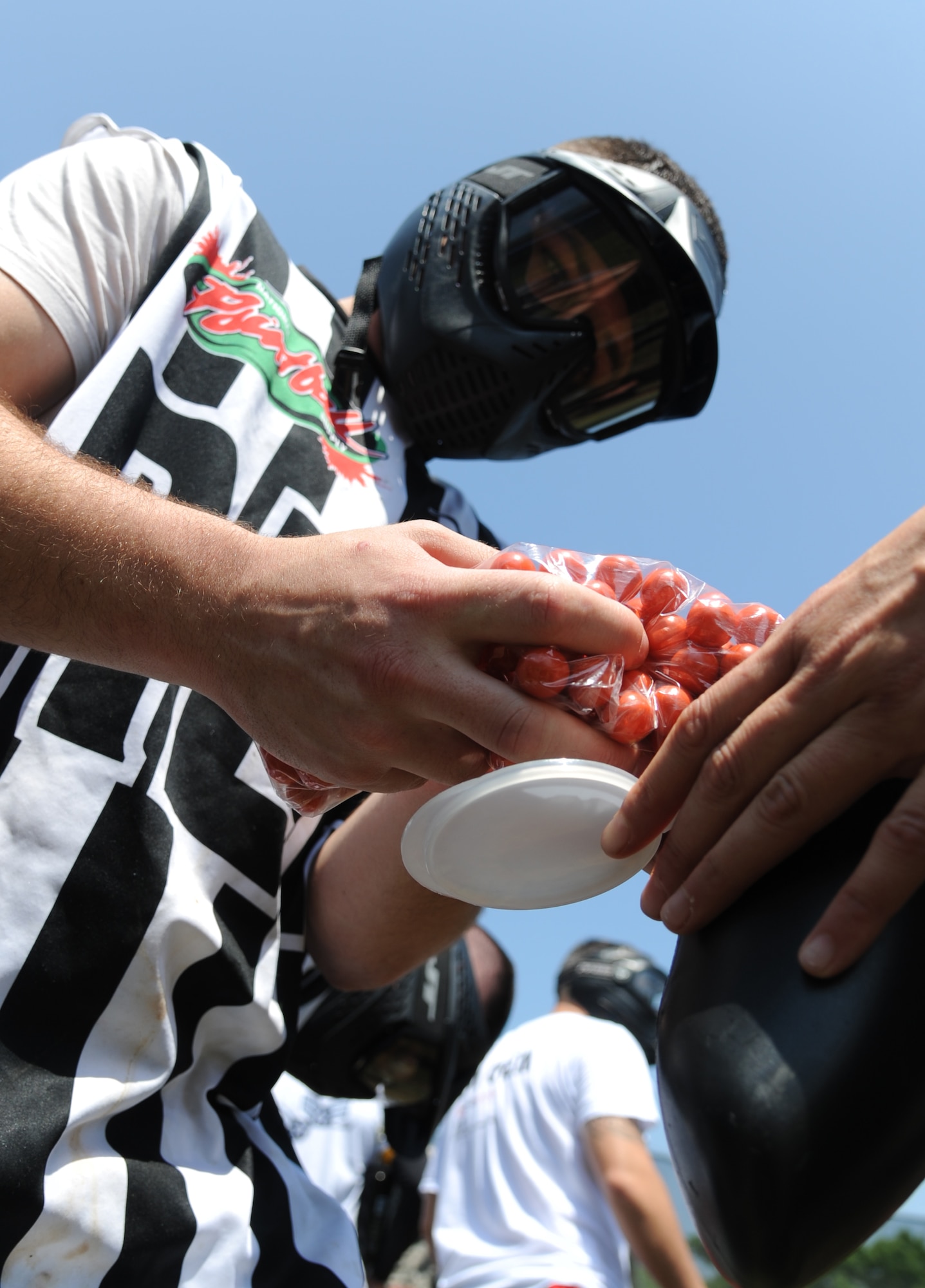Airman 1st Class Daniil Kravchuk, 338th Training Squadron, refills players’ paintball markers during the paintball facility grand opening April 25, 2014, southeast of the commissary at Keesler Air Force Base, Miss.  The paintball facility was funded with a portion of the 2013 Commander-in-Chief Installation Excellence award funds.  (U.S. Air Force photo by Kemberly Groue)