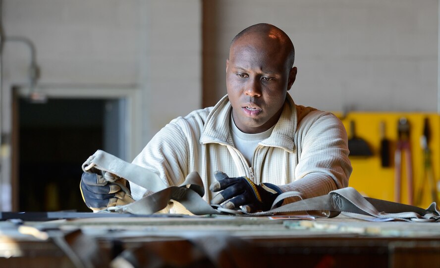 Senior Airman Jamaal Austin, 436th Aerial Port Squadron, in-transit munitions cargo processor, configures cargo netting over large pallets of LUU-2B/B aircraft flares with parachutes as the pallets are prepared for movement April 10, 2014, at Dover Air Force Base, Del. Special handling and strict protocol are followed to ensure the safety of personnel working in the area. (U.S. Air Force photo/Greg L. Davis)