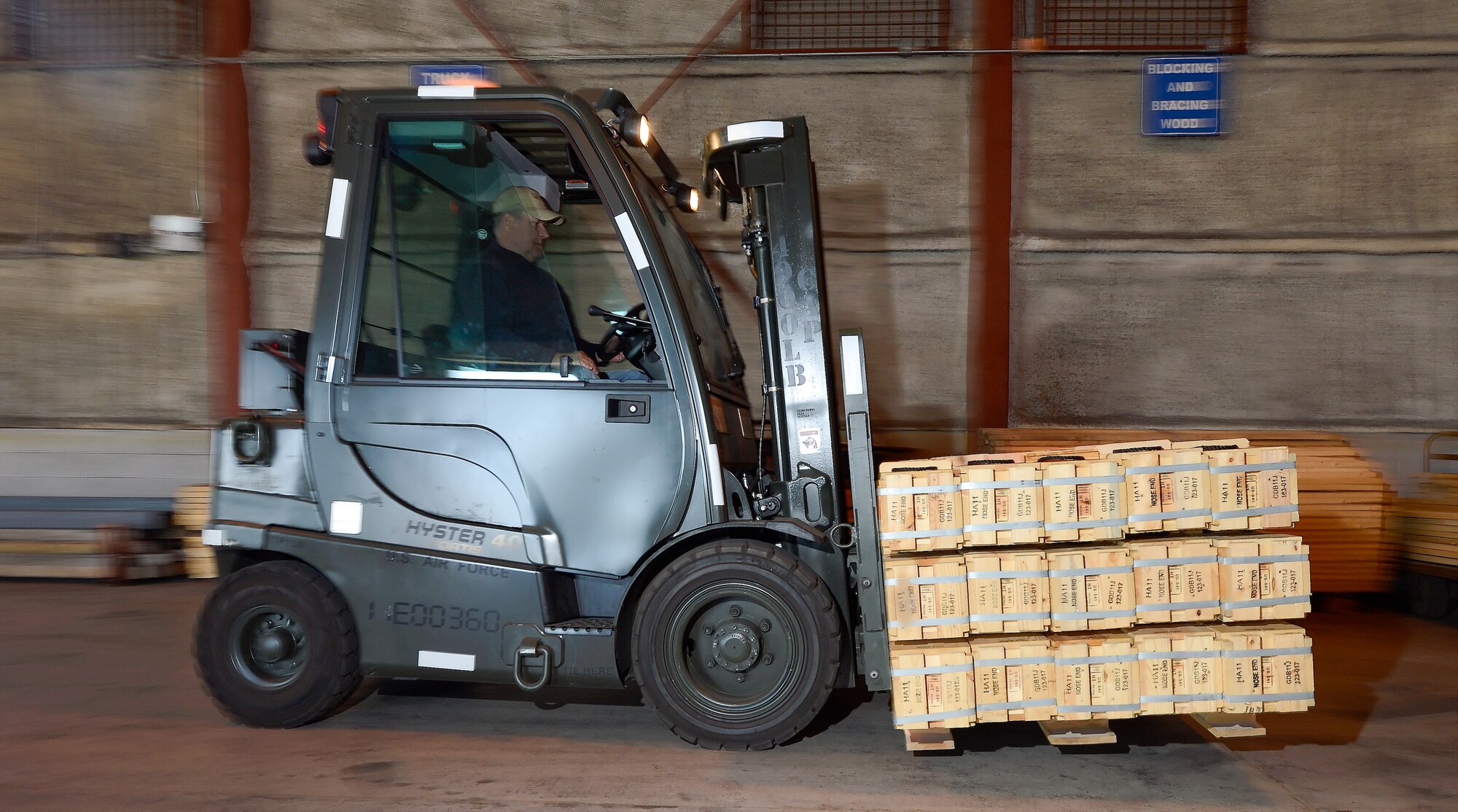 Leonard Estabrook, 436th Aerial Port Squadron in-transit munitions material handler, drives a forklift inside the warehouse facility while moving a pallet of small arms ammunition April 10, 2014, at Dover Air Force Base, Del. After being inventoried, the ammunition is moved into secure storage by forklifts or pallet-jacks. (U.S. Air Force photo/Greg L. Davis)