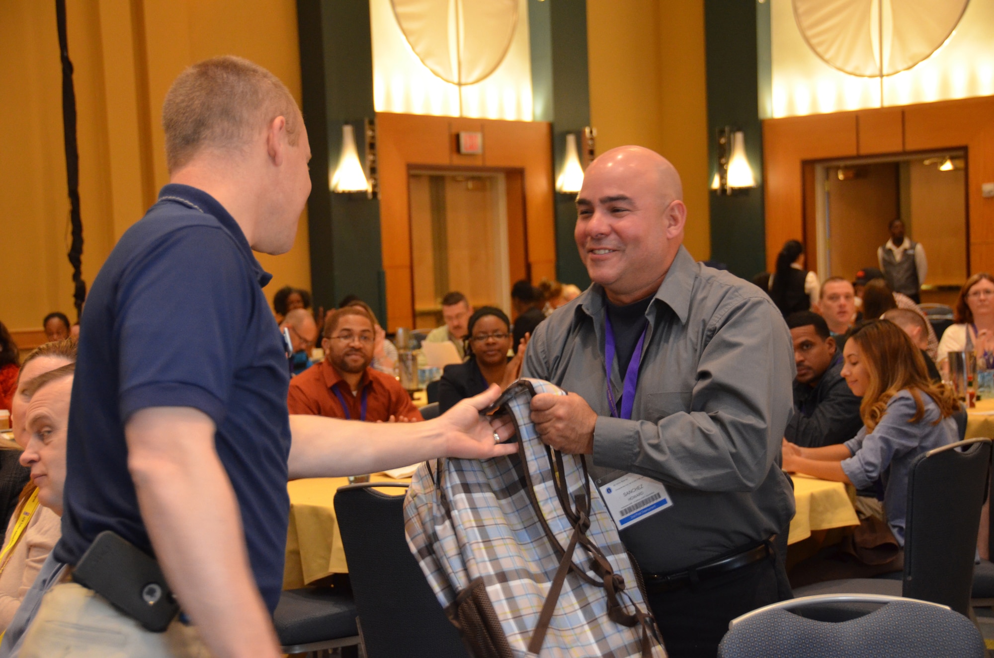Chaplain (Capt.) Matthew Hoshor (left), Maxwell Air Force Base, Ala., presents Staff Sgt. Howard Sanchez, 482nd Fighter Wing, Homestead Air Reserve Base, Fla., with a prize during a Yellow Ribbon Reintegration Program event April 26, 2014, in Maryland. The Operation Homefront backpack was bestowed for a random act of kindess Sanchez performed prior to the start of the event, which connected reservists and their families with various resources revolving around the deployment cycle. (U.S. Air Force photo/Staff Sgt. Kelly Goonan)