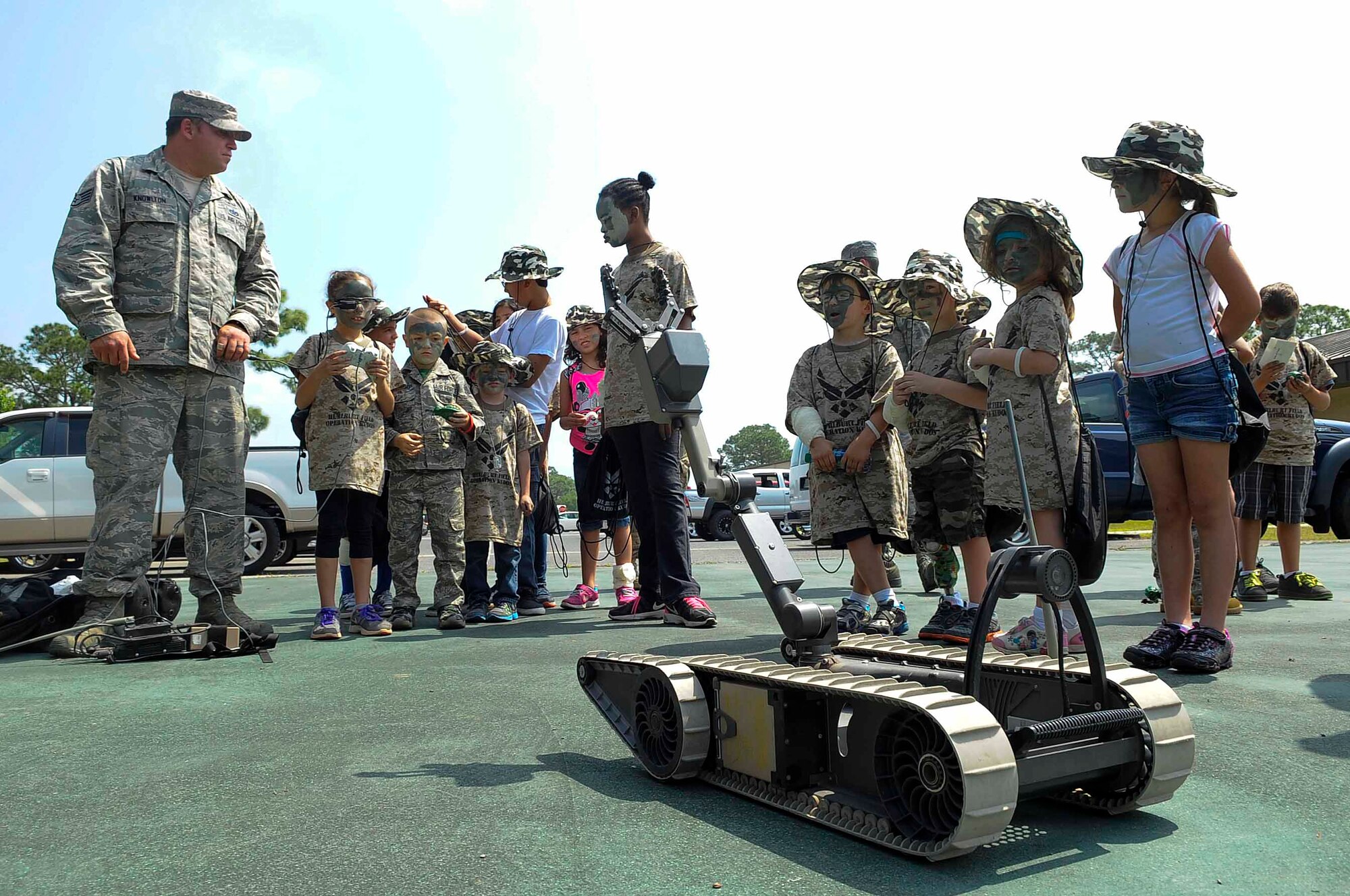 Tech. Sgt. James Wesson, 823rd RED HORSE Squadron airfield manager, teaches children about Air Force robotics at Hurlburt Field, Fla., April 26, 2014. Military children participated in Kids Understanding Deployment Operations to see what their parents go through during deployments. (U.S. Air Force photo/Airman 1st Class Andrea Posey)