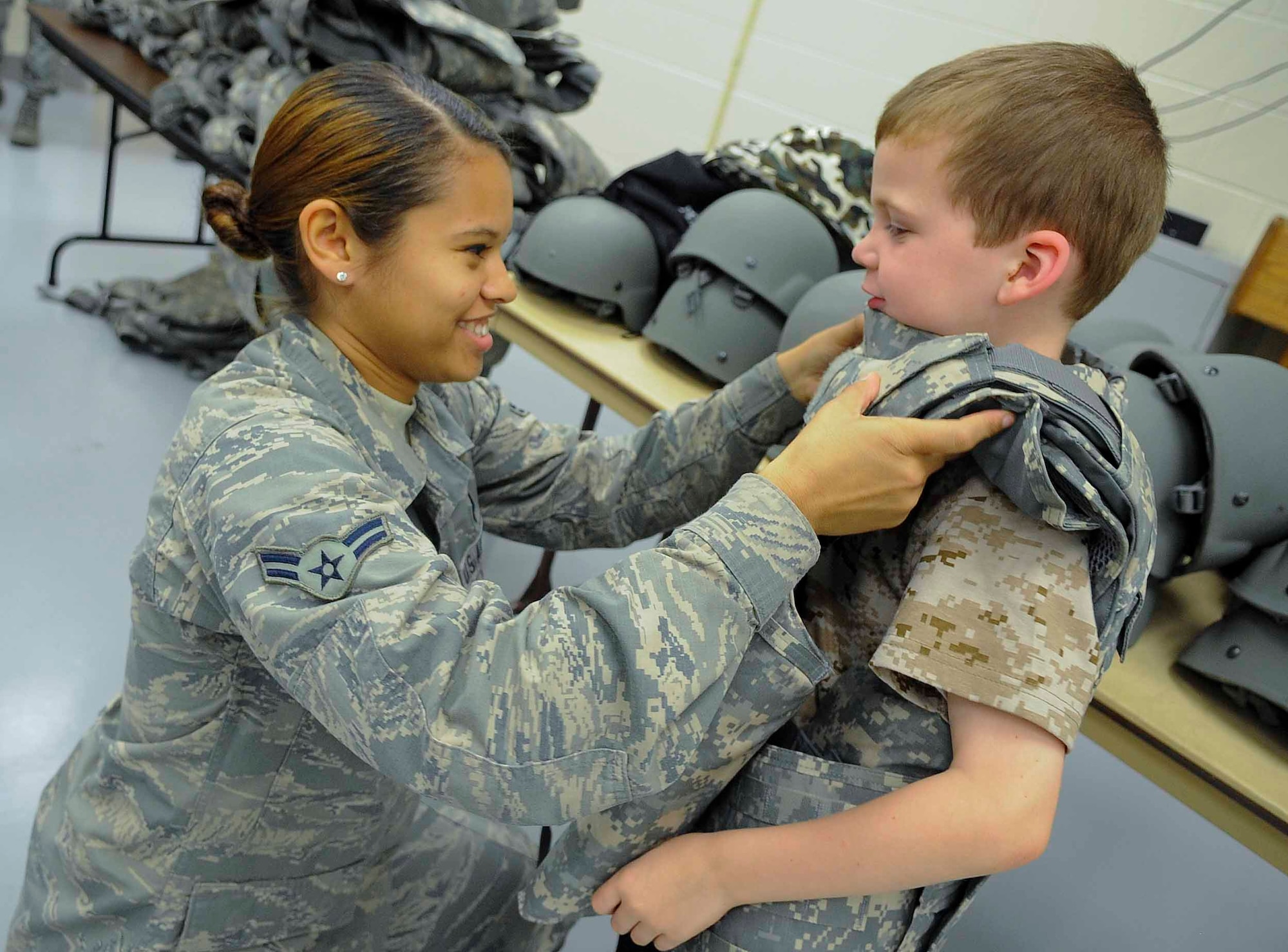 Airman 1st Class Diamond Petersen, 1st Special Operations Logistics Readiness Squadron vehicle operator, puts a vest on Jessiah Carden at Hurlburt Field, Fla., April 26, 2014. Military children participated in Kids Understanding Deployment Operations to see what their parents go through during deployments. (U.S. Air Force photo/Airman 1st Class Andrea Posey)