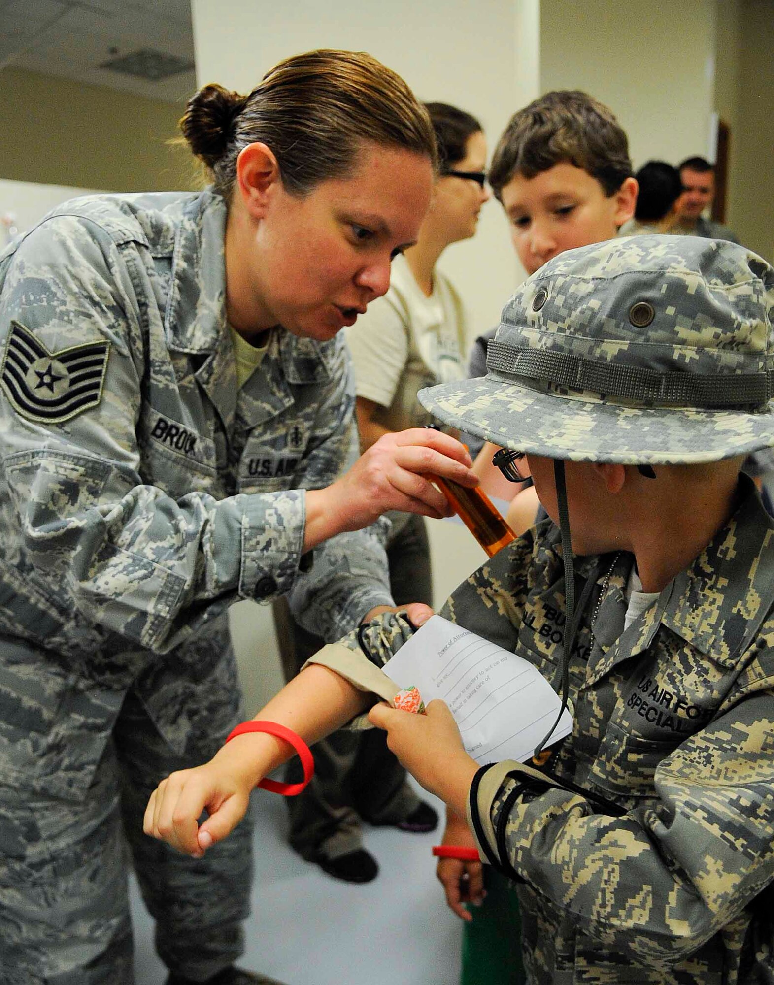Tech. Sgt. Melissa Brook, 1st Special Operations Medical Operations Squadron NCO in charge, pretends to give children shots at Hurlburt Field, Fla., April 26, 2014. Military children participated in Kids Understanding Deployment Operations to see what their parents go through during deployments. (U.S. Air Force photo/Airman 1st Class Andrea Posey)