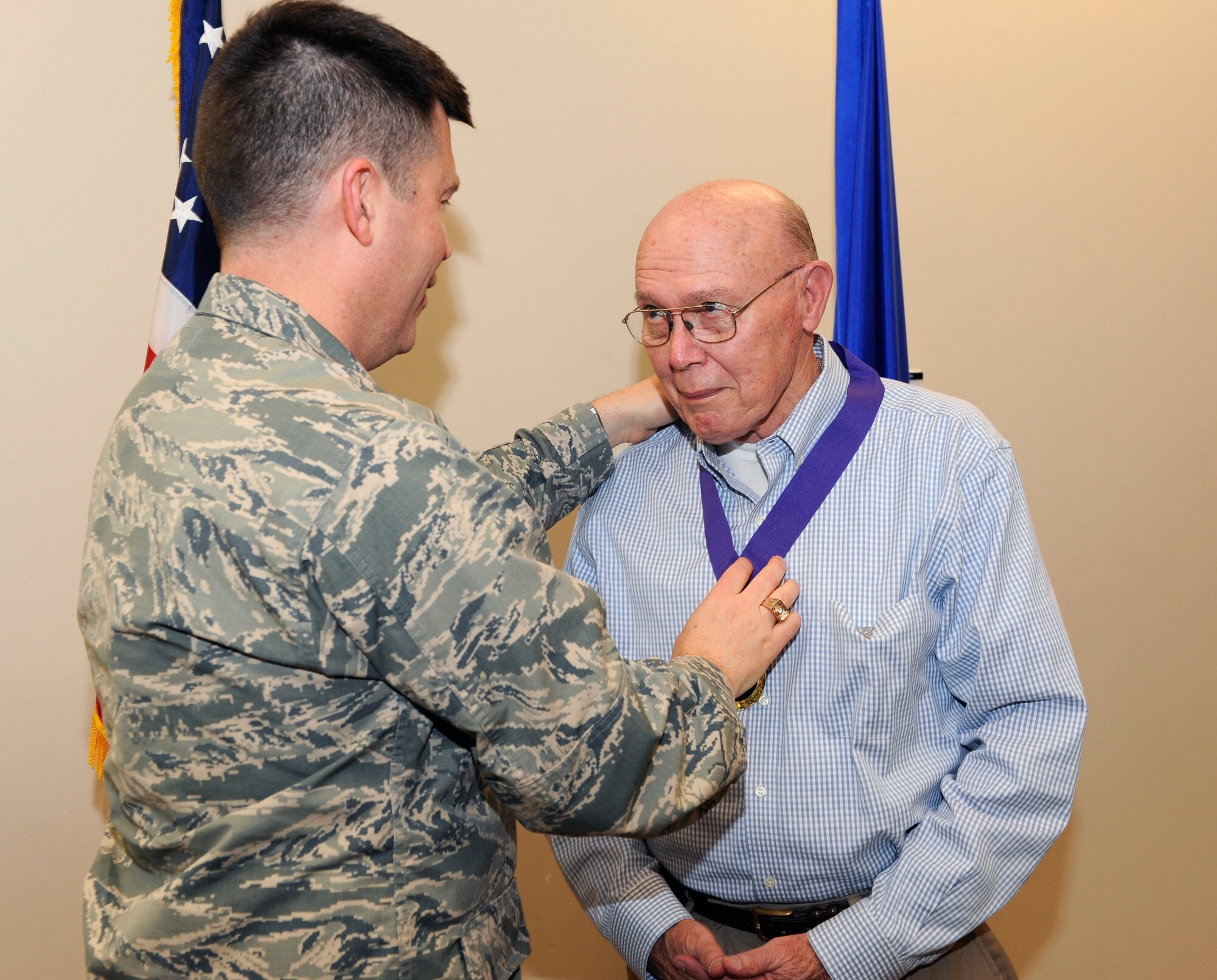 Col. Dan Wright, 460th Space Wing commander, places a medal around (Ret.) Navy Capt. Donald E. Abram’s, Buckley Pharmacy volunteer coordinator, neck during the Volunteer Excellence Award ceremony April 28, 2014, at the chapel on Buckley Air Force Base, Colo. This award is given to non-active duty military personnel to encourage retirees, military family members and civilian personnel to use their time to help others. (U.S. Air Force photo by Airman 1st Class Samantha Saulsbury/Released)