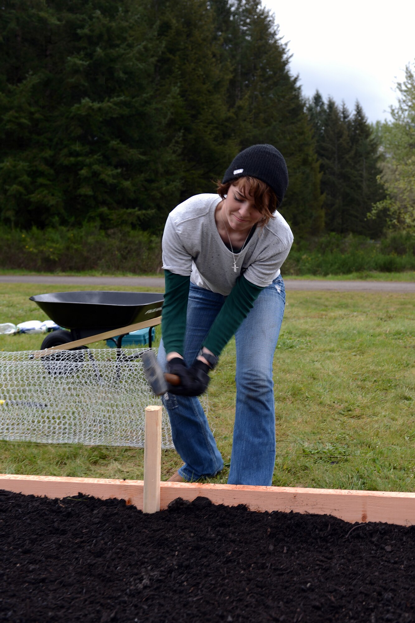 Airman 1st Class Amanda Lewis, 10th Airlift Squadron loadmaster, hammers down a stake in a garden bed April 17, 2014, during Earth Week at Joint Base Lewis-McChord, Wash. The project was one of three installation gardening projects organized by Sustainable JBLM, an installation program geared toward creating sustainable neighborhoods for a livable JBLM community that enhances the Puget Sound Region. (U.S. Air Force photo/Airman 1st Class Jacob Jimenez)
