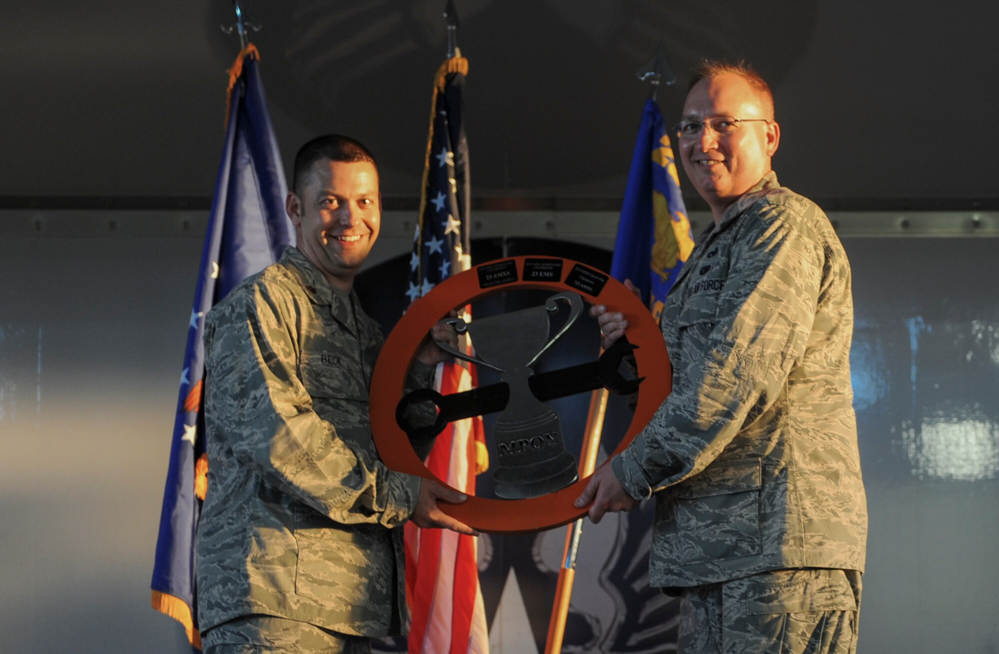 U.S. Air Force Maj. Timothy Beck, 723d Aircraft Maintenance Squadron commander, left, is presented the Maintenance Professional of the Year sports day trophy from Col. Jeffery Decker, 23d Maintenance Group commander, at Moody Air Force Base, Ga., April 25, 2014. Airmen from the 23d MXG participated in a number of sports events, and the winning squadron was awarded the trophy. (U.S. Air Force photo by Airman 1st Class Alexis Millican/Released)