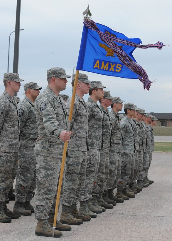 Airmen from the 28th Aircraft Maintenance Squadron stand at ease prior to a retreat ceremony at Ellsworth Air Force Base, S.D., April 18, 2014. Each month, a squadron on base performs a retreat ceremony at the base flagpole in front of the 28th Bomb Wing Headquarters building as a way of remembering and honoring the Air Force heritage. (U.S. Air Force photo by Airman 1st Class Rebecca Imwalle/released)