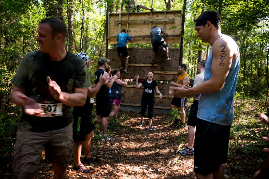 U.S. Air Force Tech. Sgt. Sasha Barker (center), 347th Operations Support Squadron, receives applause and high-fives after completing a wall climb during the Moody Mudder run April, 26, 2014, in Ray City, Ga. During the wall climb, Barker conquered her fear of heights. (U.S. Air Force photo by Staff Sgt. Jamal D. Sutter/Released)