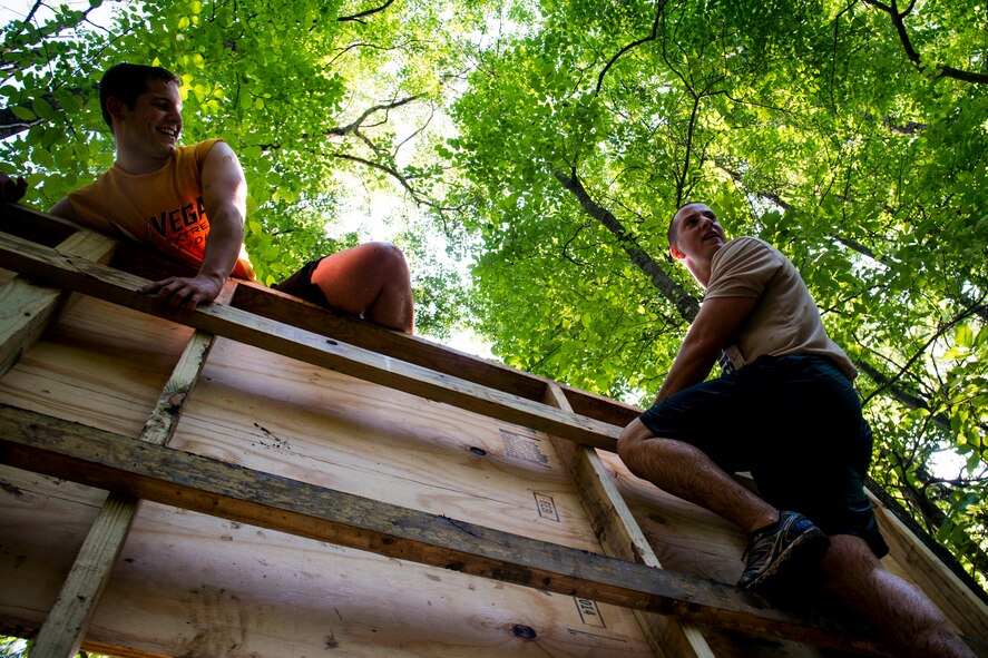 Two Moody Mudder participants make their way over a wall April 26, 2014, in Ray City, Ga. More than 500 participants tested their strength and endurance during the 10-obstacle course. (U.S. Air Force photo by Staff Sgt. Jamal D. Sutter/Released)