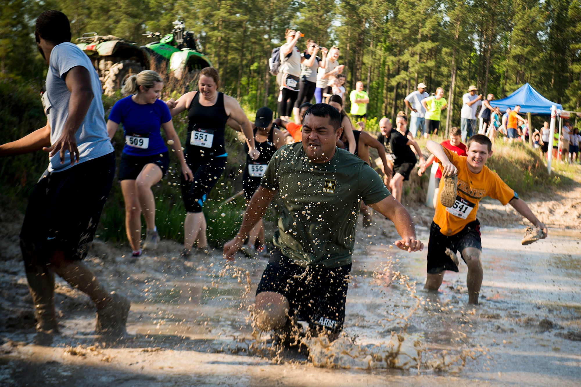 Participants run through the first obstacle of the Moody Mudder event April 26, 2014, in Ray City, Ga. The first obstacle was a mud pit that reached depths up to five feet. (U.S. Air Force photo by Staff Sgt. Jamal D. Sutter/Released)