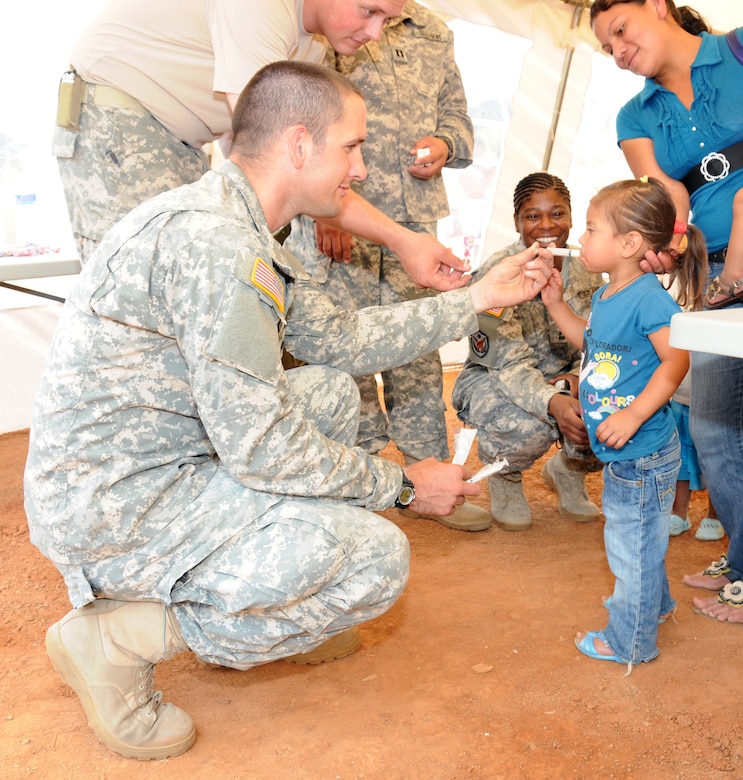 U. S. Army Spc. Liam Dooley gives a Honduran child medicine as part of the preventive medicine program during a Medical Readiness Training Exercise in El Naranjo, a remote village in the La Paz region of Honduras, April 24-25.  The Medical Element, with support from JTF-Bravo Joint Security Forces, partnered with the Honduran Ministry of Health, the Honduran National Police, and the Honduran military to provide medical care to nearly 1,000 people over a two day period.  The teams worked together to provide preventive medicine to their patients which included classes on hygiene, hand washing, preventive dental care, and nutrition.  They also provided immunizations to infants, dental care, well women screenings, wellness checkups, medications, and minor medical procedures.  (Photo by U. S. Air National Guard Capt. Steven Stubbs)