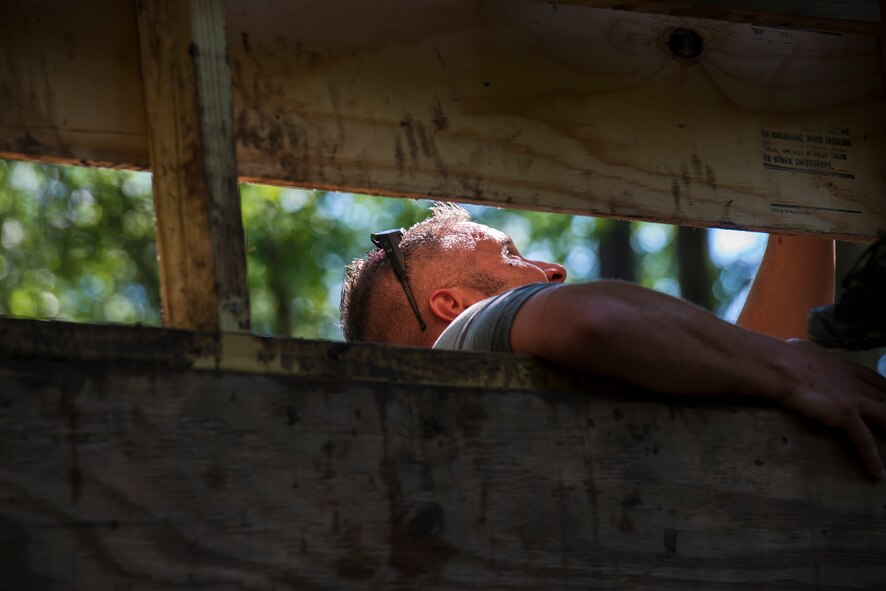 A runner helps a fellow participant get to the top of a climbing wall during a mud-run in Ray City, Ga., April 26, 2014. The inaugural Moody Mudder 5k had more than 500 participants comprised of Moody Airmen and their families as well as members of the local community. Throughout the 3.12 miles, runners had to overcome obstacles such as barbed wire, monkey bars, low crawls, balance beams and climbing walls. (U.S. Air Force photo by Airman 1st Class Ryan Callaghan/Released)