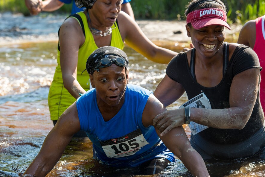 Runners navigate a small creek during a mud-run in Ray City, Ga., April 26, 2014. The inaugural Moody Mudder 5k had more than 500 participants comprised of Moody Airmen and their families as well as members of the local community. Throughout the 3.12 miles, runners had to overcome obstacles such as barbed wire, monkey bars, low crawls, balance beams and climbing walls. (U.S. Air Force photo by Airman 1st Class Ryan Callaghan/Released)