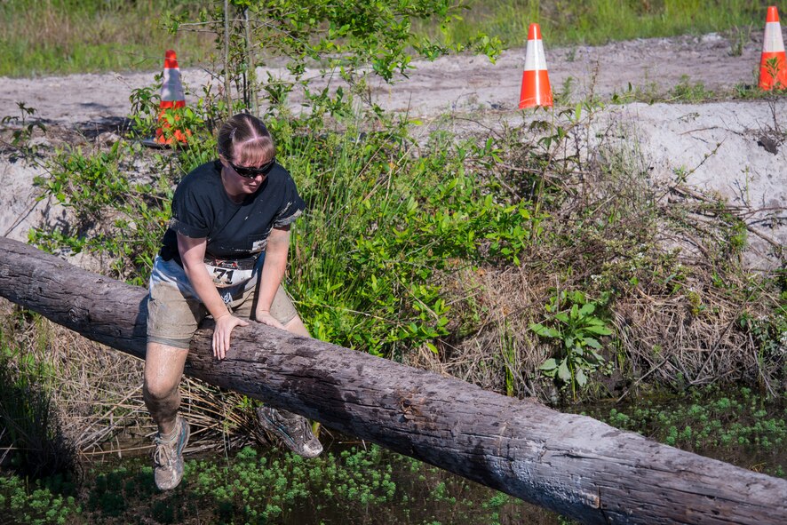 U.S. Air Force Staff Sgt. Stacy Sconzert, 23d Operations Support Squadron weather technician, takes a cautious approach to crossing the log balance beam during a mud-run in Ray City, Ga., April 26, 2014. The inaugural Moody Mudder 5k had more than 500 participants comprised of Moody Airmen and their families as well as members of the local community. Throughout the 3.12 miles, runners had to overcome obstacles such as barbed wire, monkey bars, low crawls, balance beams and climbing walls. (U.S. Air Force photo by Airman 1st Class Ryan Callaghan/Released)
