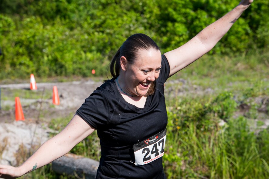 U.S. Air Force Tech. Sgt. Sasha Barker, 347th Operations Support Squadron independent duty medical technician, maintains her balance across a log balance beam obstacle during a mud-run in Ray City, Ga., April 26, 2014. The inaugural Moody Mudder 5k had more than 500 participants comprised of Moody Airmen and their families as well as members of the local community. Throughout the 3.12 miles, runners had to overcome obstacles such as barbed wire, monkey bars, low crawls, balance beams and climbing walls. (U.S. Air Force photo by Airman 1st Class Ryan Callaghan/Released)